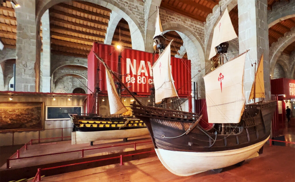 バルセロナ海洋博物館（Museu Marítim de Barcelona） 館内に展示されている帆船の模型と、背後の赤と白のコンテナを模した展示デザイン。