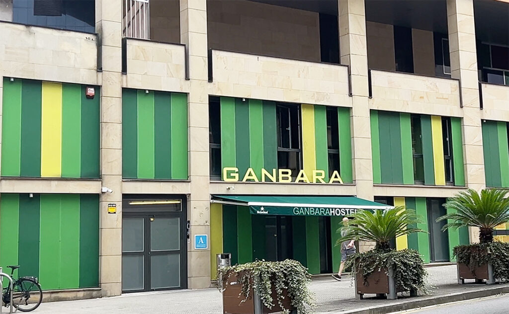 ビルバオ Bilbao 人気のホステル「Ganbara Hostel」の外観。緑と黄色のストライプが鮮やかで、モダンなデザインが目を引く。