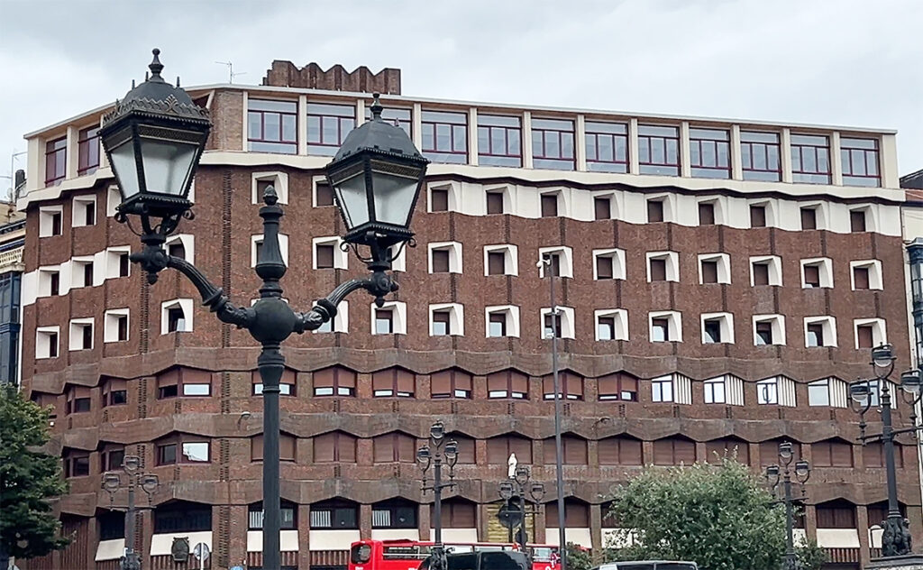 ビルバオ Bilbao ビルバオの伝統的なレンガ造りと、現代的な幾何学デザインが融合した非常に特徴的なビルバオを代表する近代建築の一つ。スペインを代表する建築家サエンス・デ・オイサによって1970年代に設計された。この建物の最大の特徴である「ジグザグの窓（出窓）」は、北スペイン特有の曇り空から少しでも多くの太陽光を取り込むために計算し尽くされたもの。