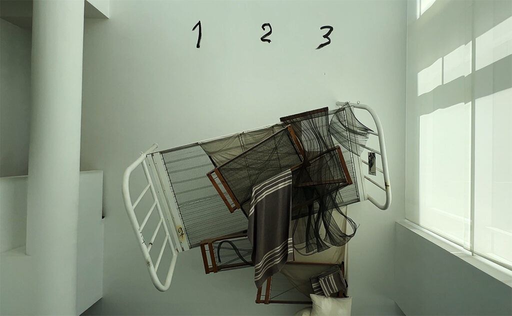 バルセロナ現代美術館(MACBA: Museu d'Art Contemporani de Barcelona) 白い壁面に浮遊するように設置されたベッドのフレームと、その上に描かれた数字が印象的なインスタレーション。