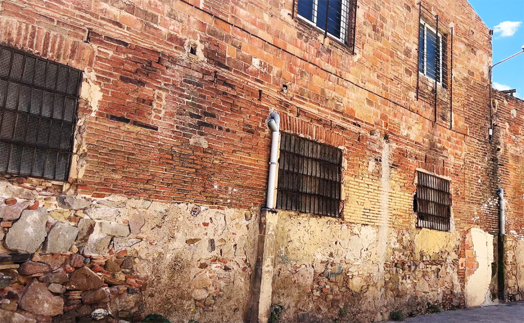 バルセロナ（Barcelona）ファブラ・イ・コーツ（Fabra i Coats）レンガ壁の下層部に石材が露出した広範囲な壁面