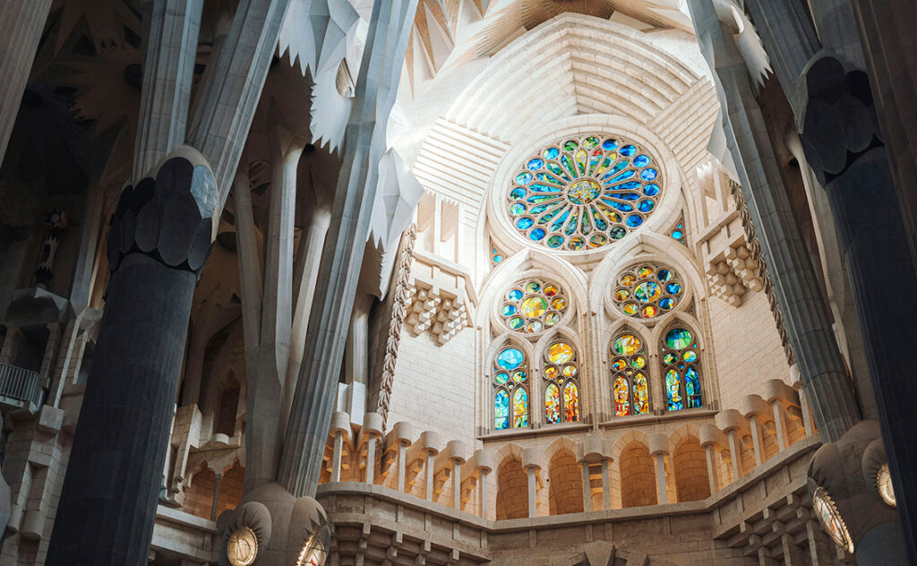 サグラダ・ファミリア（Basílica de la Sagrada Família） バルセロナ(Barcelona) 聖堂内部。青や赤のガラス越しに差し込む自然光は、白に近い砂岩や花崗岩の柱に複雑な陰影を落としている。
